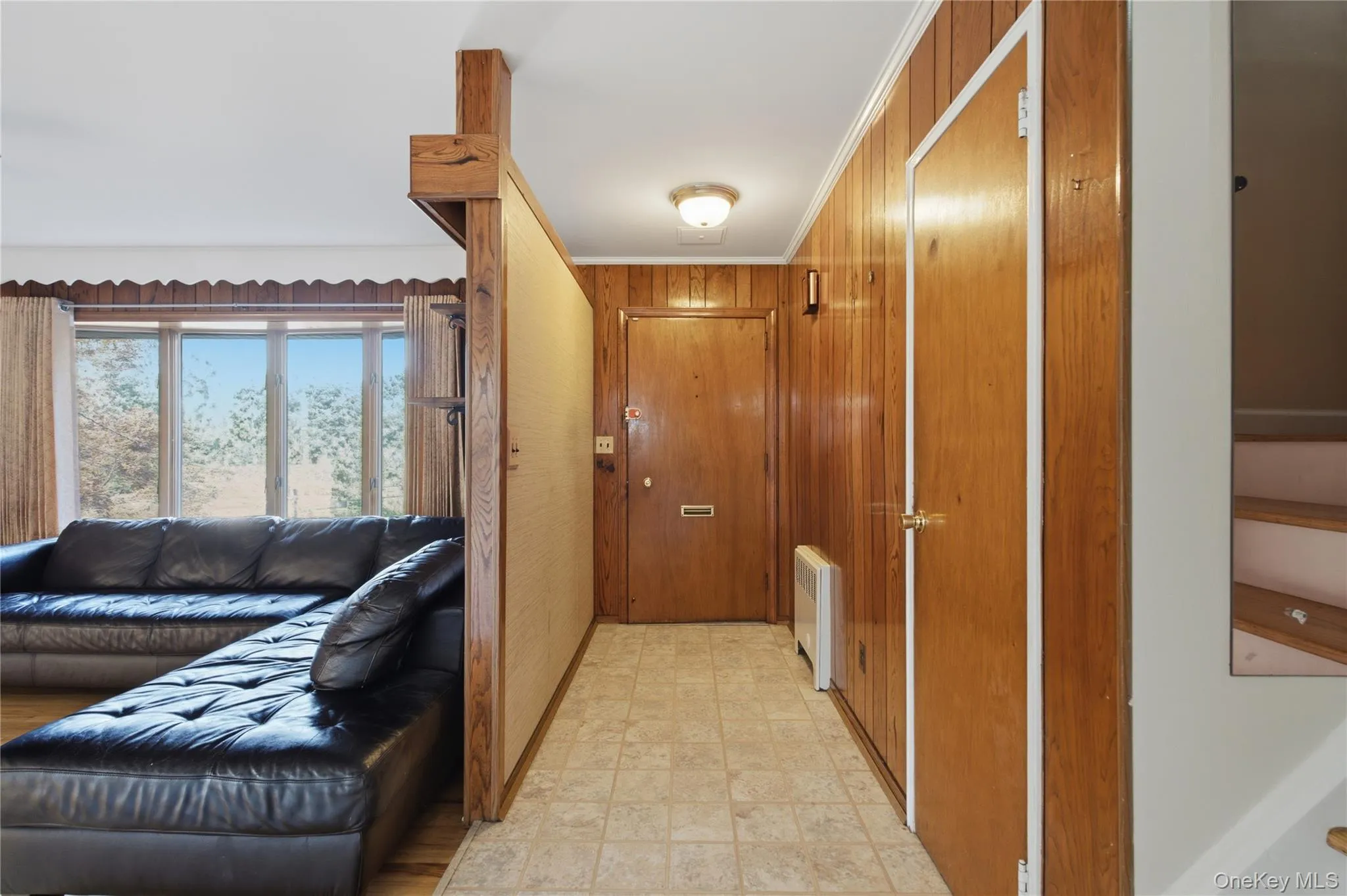 Wood-paneled entryway featuring tiled flooring and a built-in wall heater Wood-paneled entryway featuring tiled flooring and a built-in wall heater