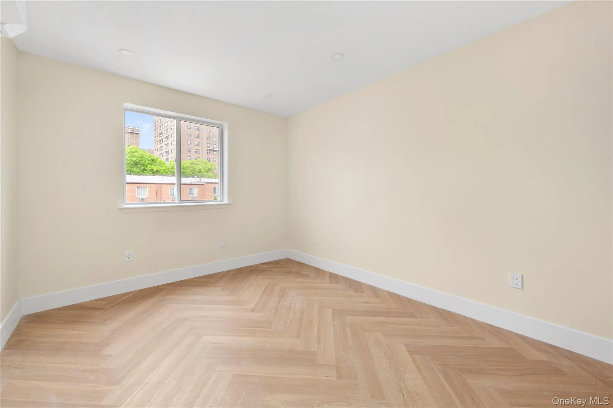 Bedroom 3 featuring light-toned walls, herringbone wood-finish flooring, recessed lighting, and a white-framed window. Bedroom 3 featuring light-toned walls, herringbone wood-finish flooring, recessed lighting, and a white-framed window.