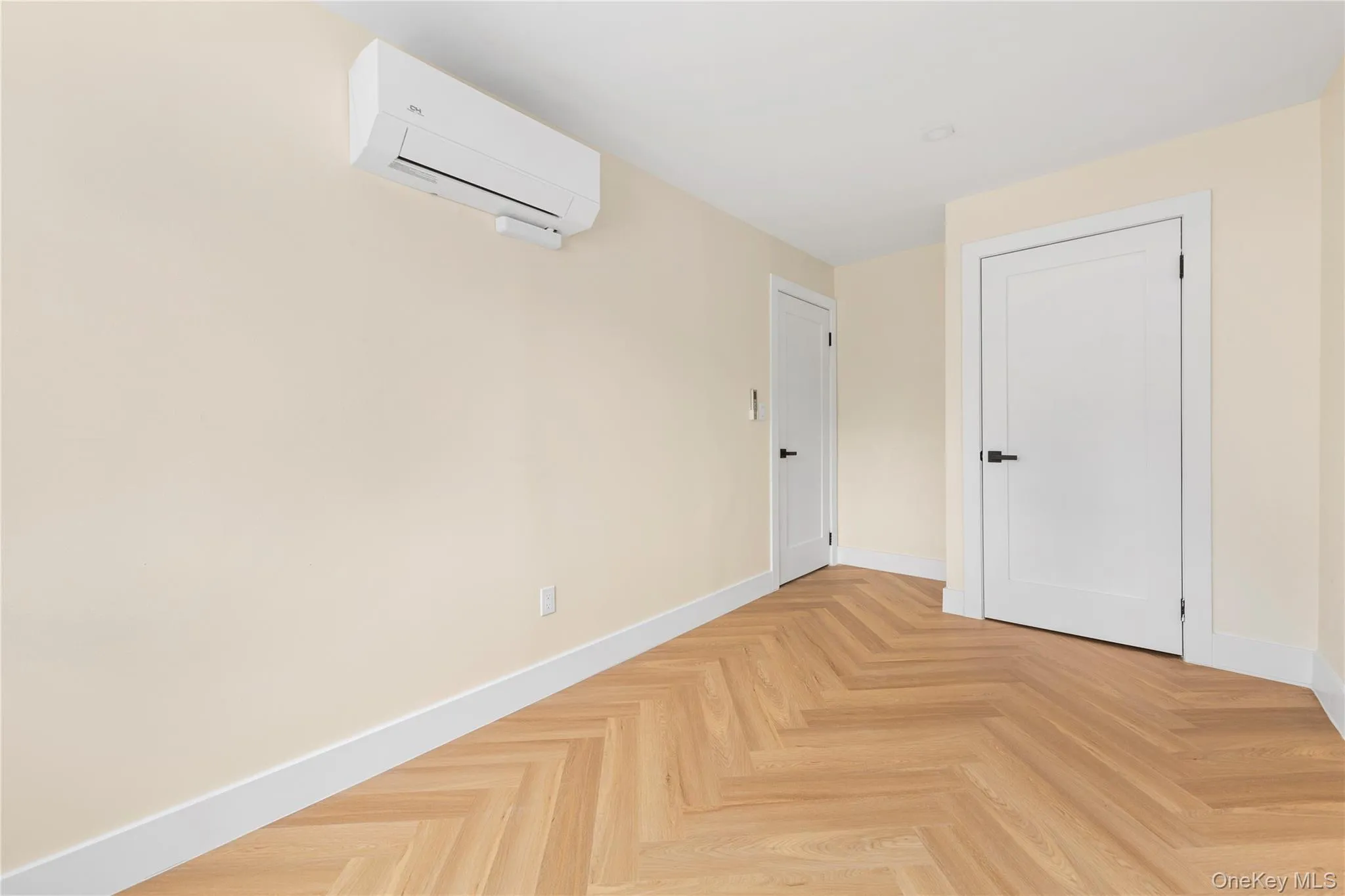 Bedroom 2 featuring light-toned walls, herringbone wood-finish flooring, recessed lighting, and a white-framed window Bedroom 2 featuring light-toned walls, herringbone wood-finish flooring, recessed lighting, and a white-framed window