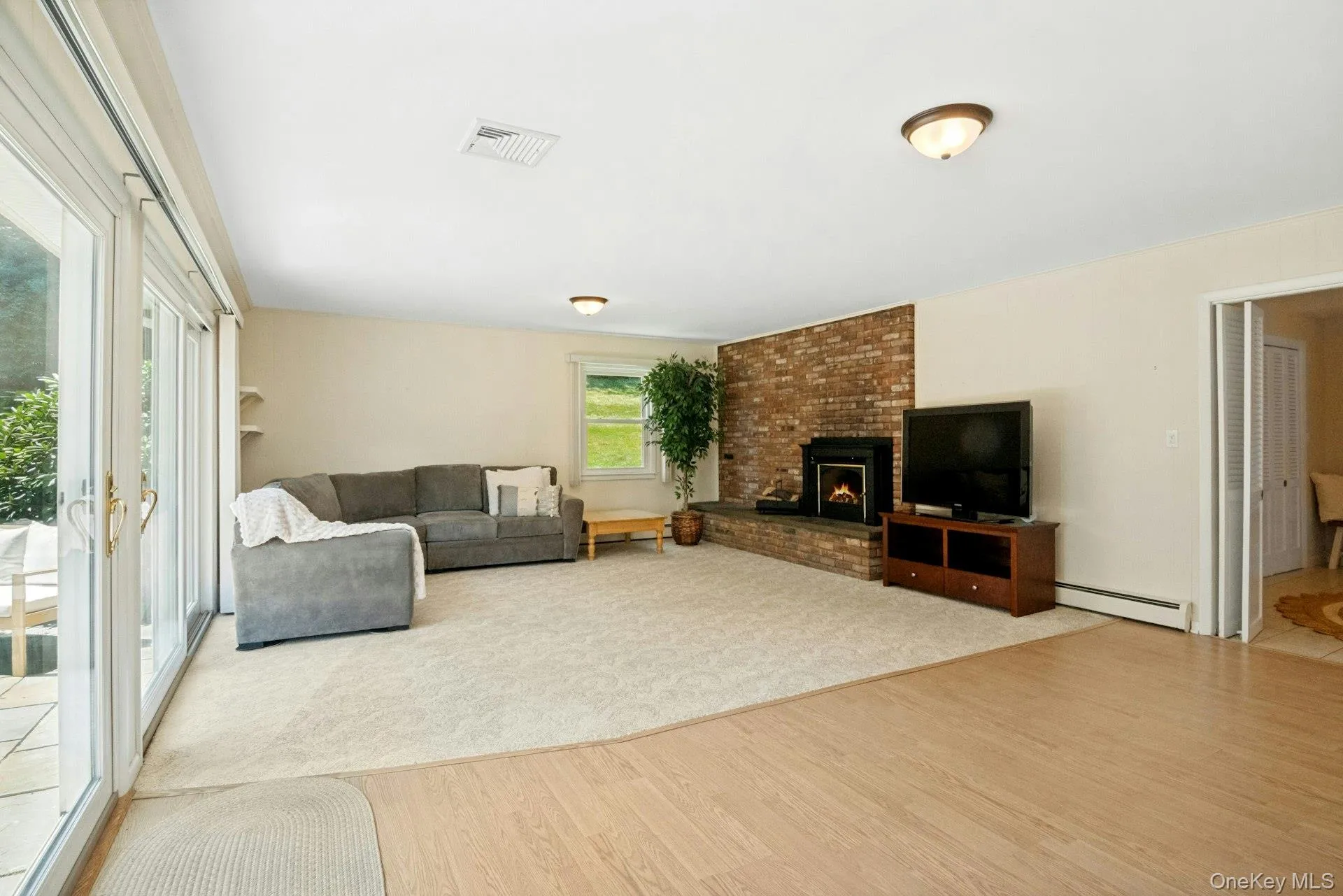 Large family room with cozy fireplace and energy efficient sliding glass doors out to the patio. Large family room with cozy fireplace and energy efficient sliding glass doors out to the patio.