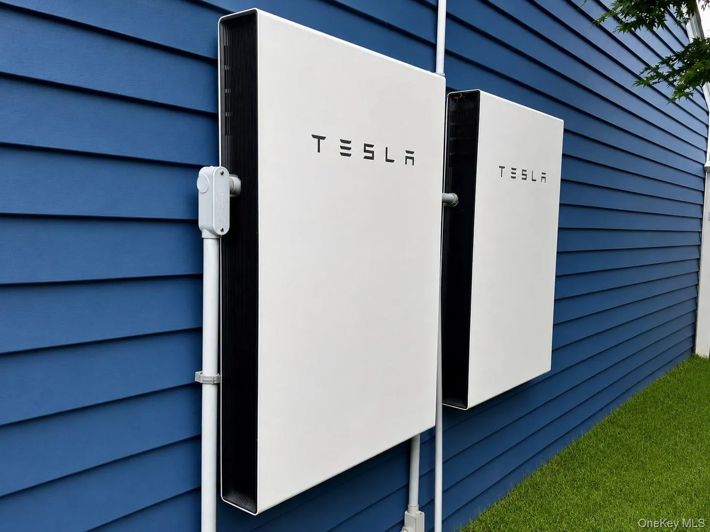 Two exterior-mounted Tesla Powerwall units against back wall of Detached Garage Two exterior-mounted Tesla Powerwall units against back wall of Detached Garage