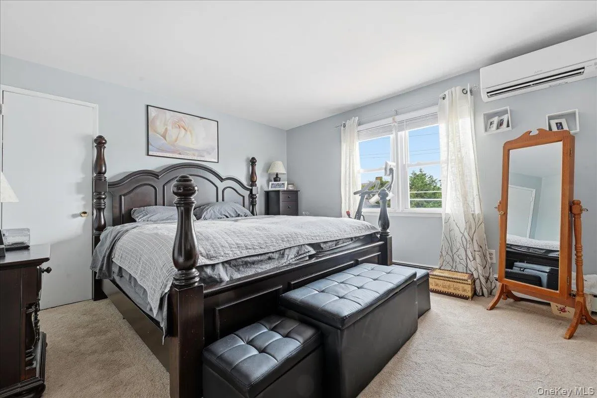 Spacious bedroom featuring light blue walls, two large windows, and wall-to-wall carpeting Spacious bedroom featuring light blue walls, two large windows, and wall-to-wall carpeting