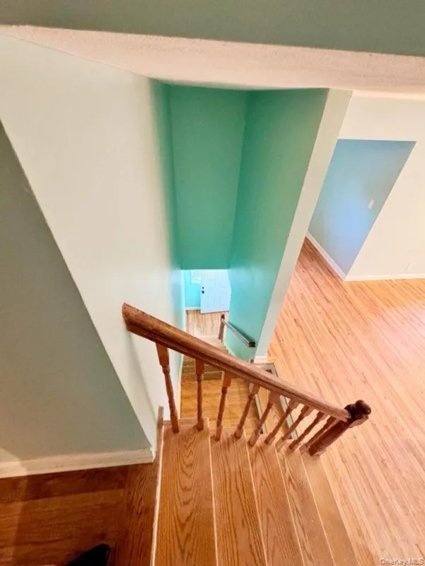 Staircase featuring hardwood / wood-style floors Staircase featuring hardwood / wood-style floors