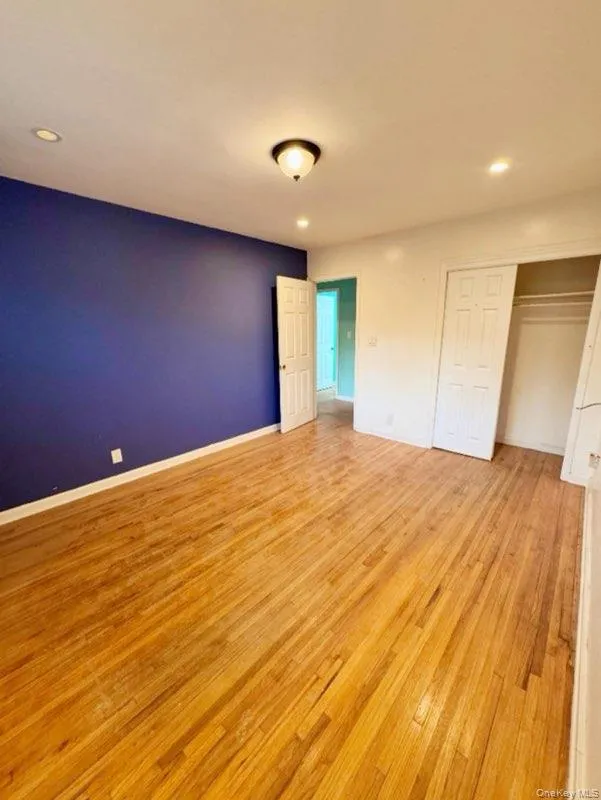 Unfurnished bedroom with light hardwood / wood-style floors and a closet Unfurnished bedroom with light hardwood / wood-style floors and a closet