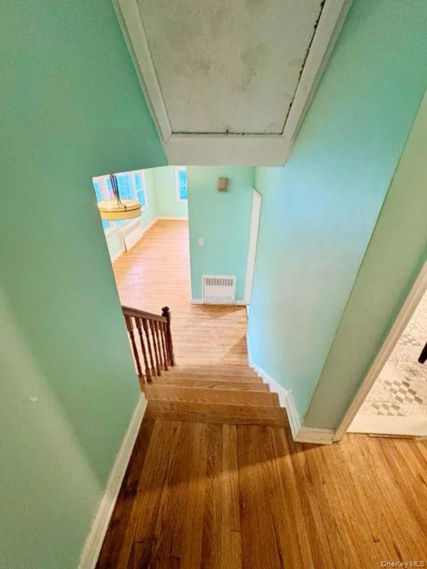 Stairs featuring hardwood / wood-style flooring and track lighting Stairs featuring hardwood / wood-style flooring and track lighting
