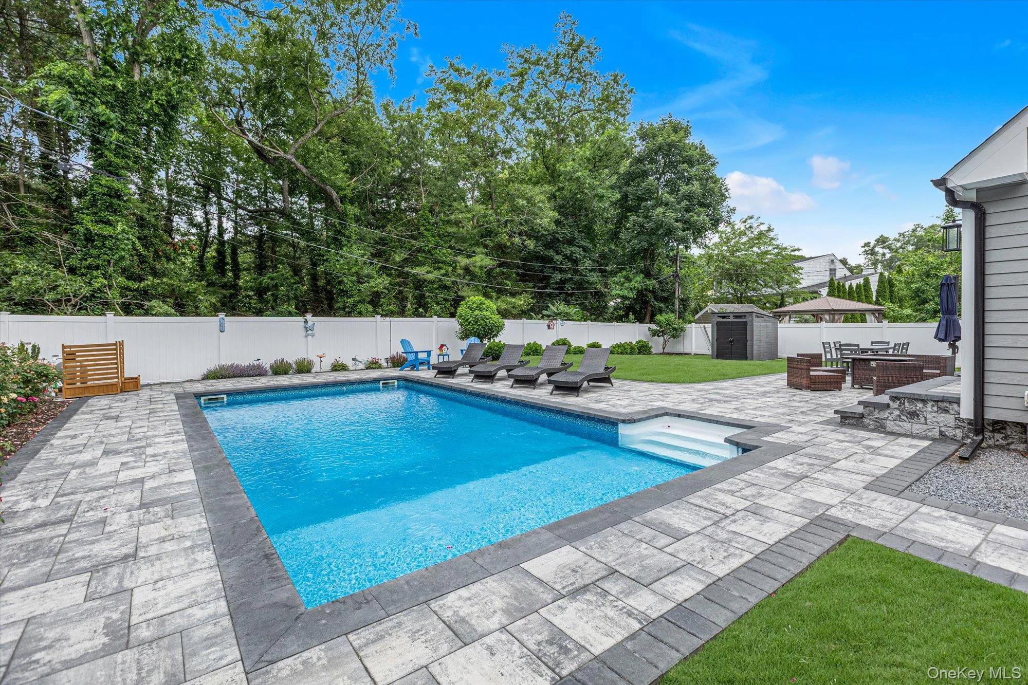 In-ground pool with beautiful paved patio surround and decorative landscaping. In-ground pool with beautiful paved patio surround and decorative landscaping.
