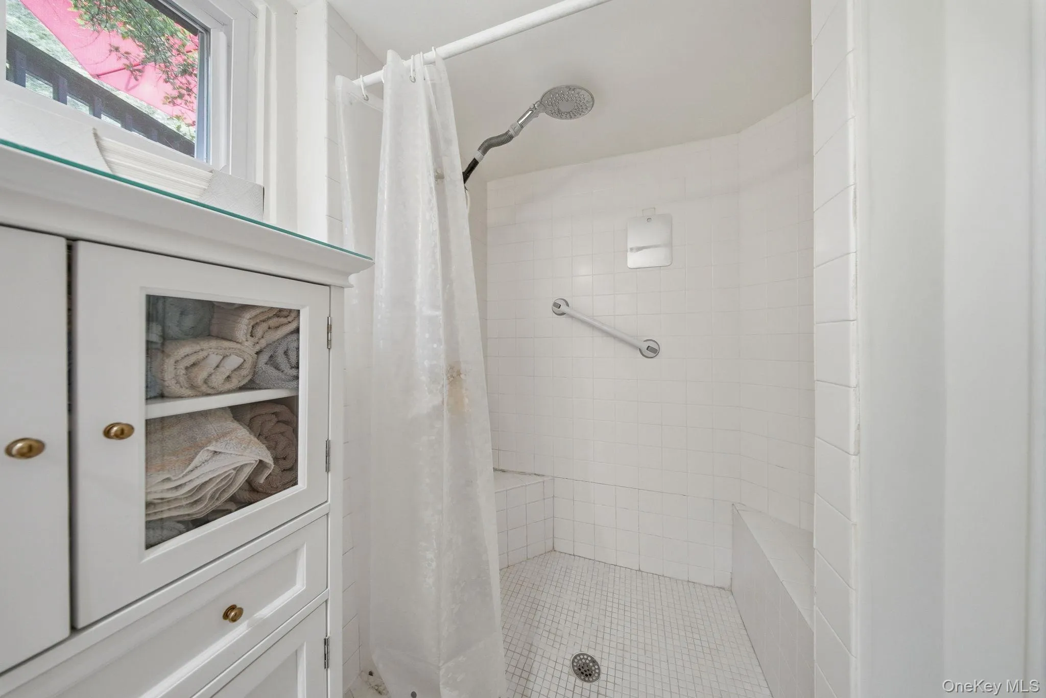 2nd Bathroom. Shower area featuring white subway tile walls and a white mosaic tile floor 2nd Bathroom. Shower area featuring white subway tile walls and a white mosaic tile floor