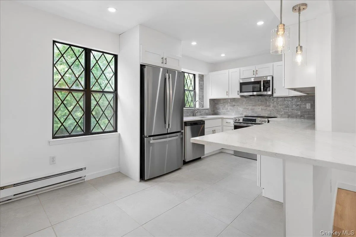 Eat-in kitchen with quartz counters, peninsula, and stainless steel appliances. Eat-in kitchen with quartz counters, peninsula, and stainless steel appliances.