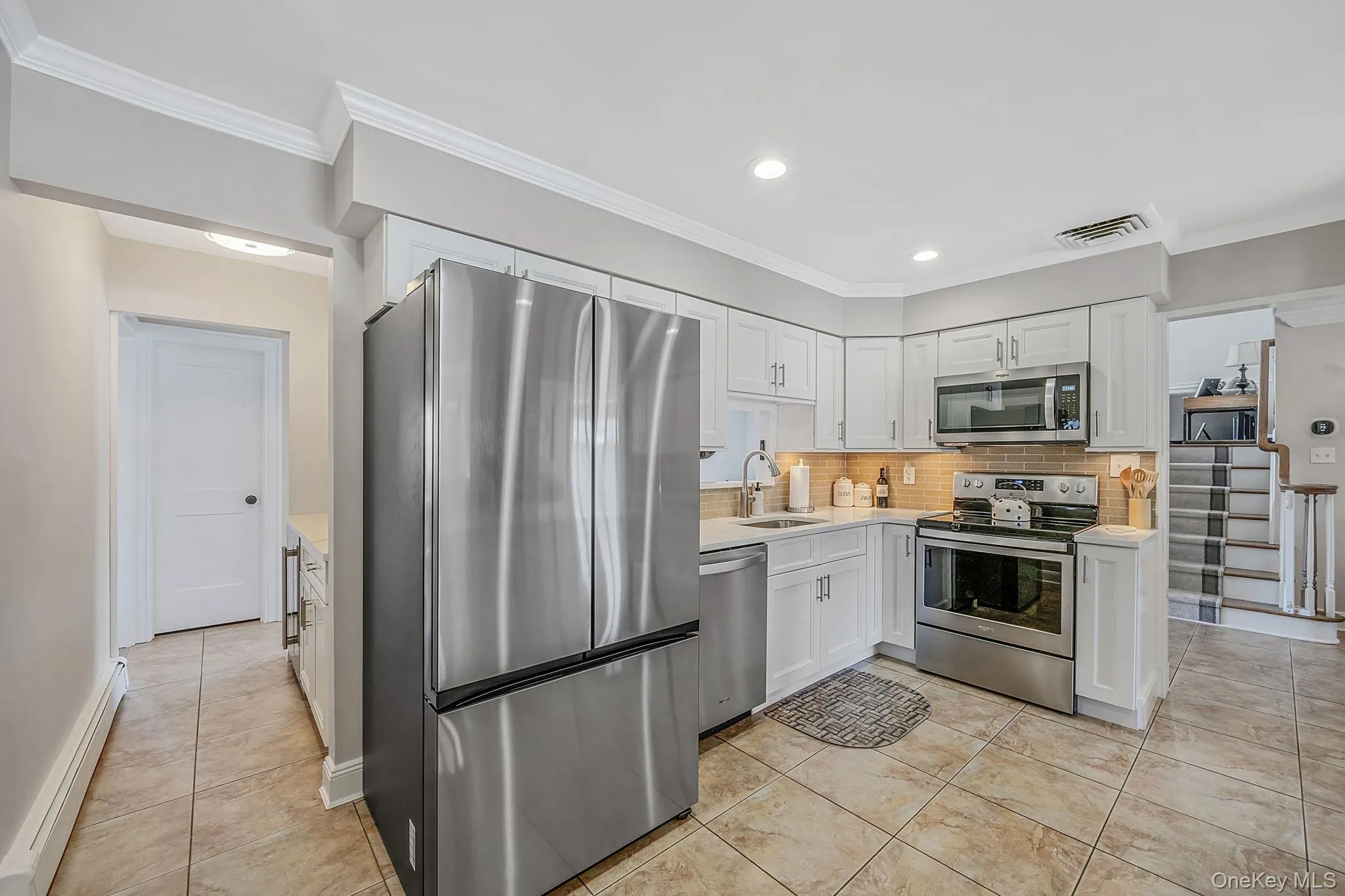 Spacious and Updated EIK with White Shaker Cabinetry, Quartz Countertops, SS Appliances, Pantry, Butler Pantry with Beverage Fridge, Recessed Lighting, Crown Molding Spacious and Updated EIK with White Shaker Cabinetry, Quartz Countertops, SS Appliances, Pantry, Butler Pantry with Beverage Fridge, Recessed Lighting, Crown Molding