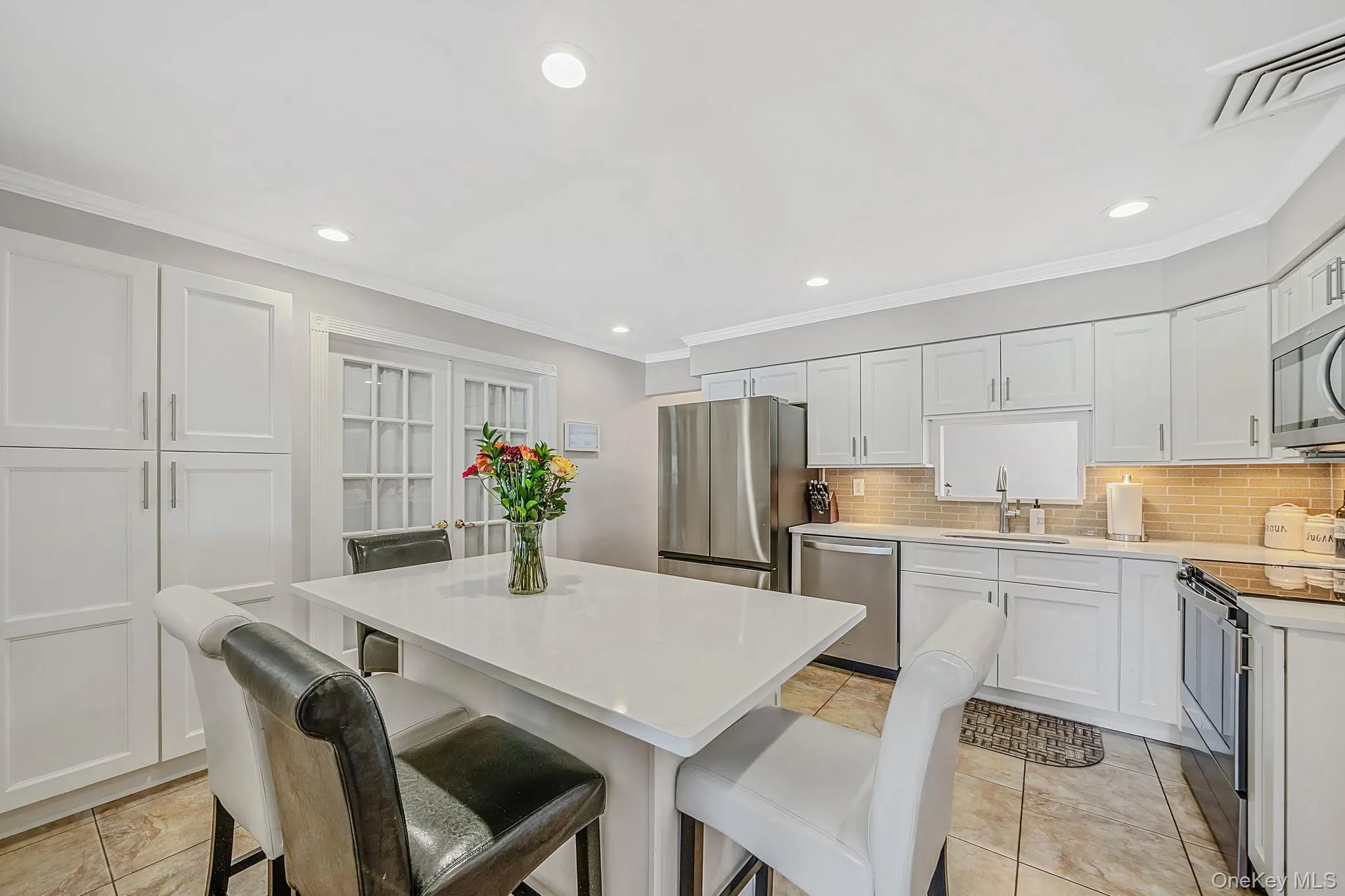 Spacious and Updated EIK with White Shaker Cabinetry, Quartz Countertops, SS Appliances, Pantry, Butler Pantry with Beverage Fridge, Recessed Lighting, Crown Molding Spacious and Updated EIK with White Shaker Cabinetry, Quartz Countertops, SS Appliances, Pantry, Butler Pantry with Beverage Fridge, Recessed Lighting, Crown Molding