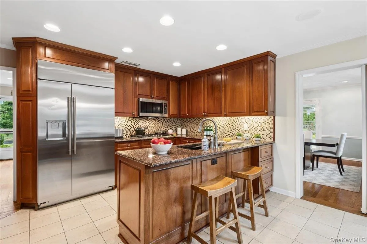 Chef's kitchen with island and GE Monogram stainless steel appliances. Chef's kitchen with island and GE Monogram stainless steel appliances.