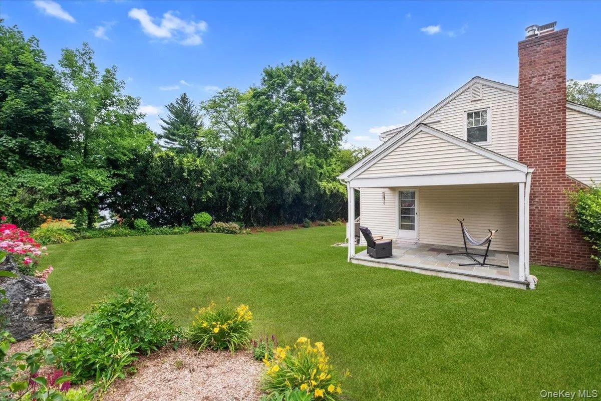 Expansive green lawn with mature perimeter trees, view from side of house. Expansive green lawn with mature perimeter trees, view from side of house.
