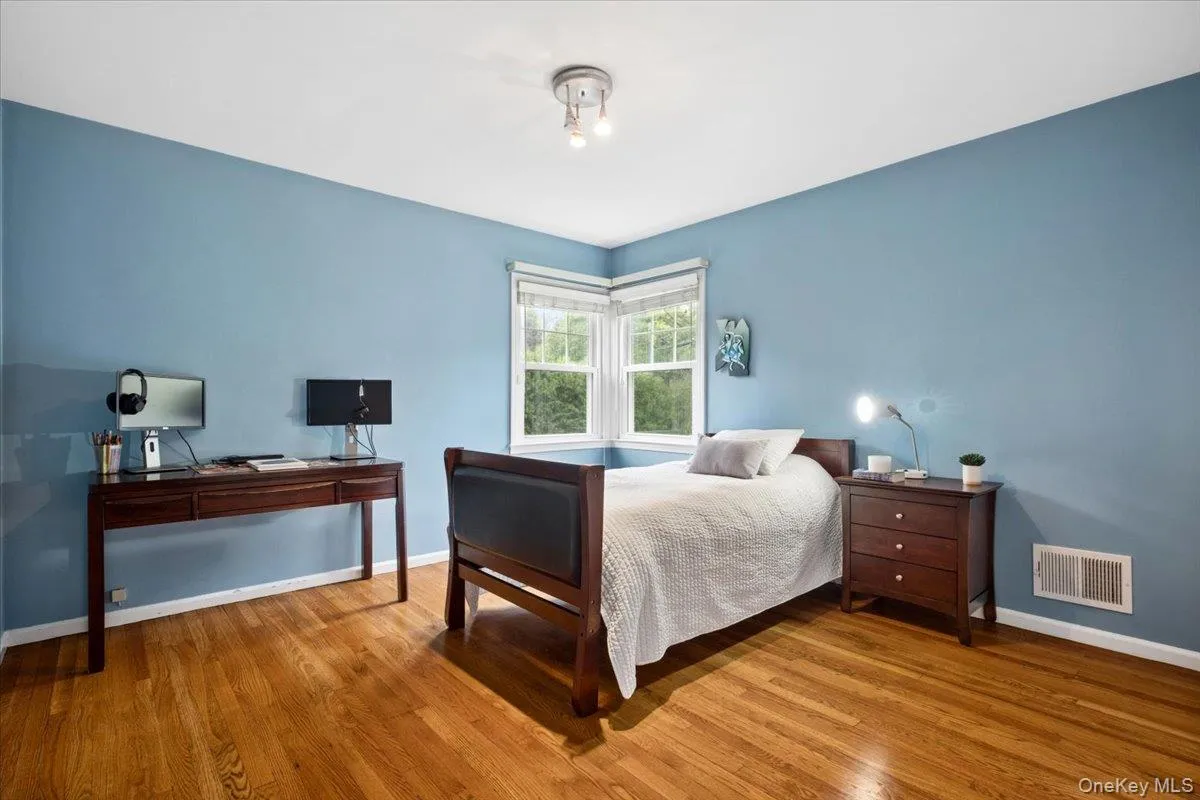 Hardwood flooring throughout this bedroom featuring a corner window with bright natural light. Hardwood flooring throughout this bedroom featuring a corner window with bright natural light.