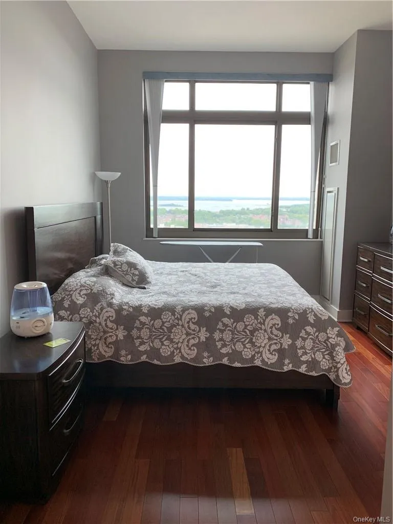 Bedroom with multiple windows and wood-type flooring Bedroom with multiple windows and wood-type flooring