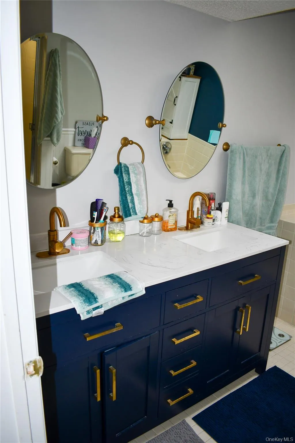 Dual vanity featuring a navy blue cabinet base, white countertop, and integrated sinks Dual vanity featuring a navy blue cabinet base, white countertop, and integrated sinks