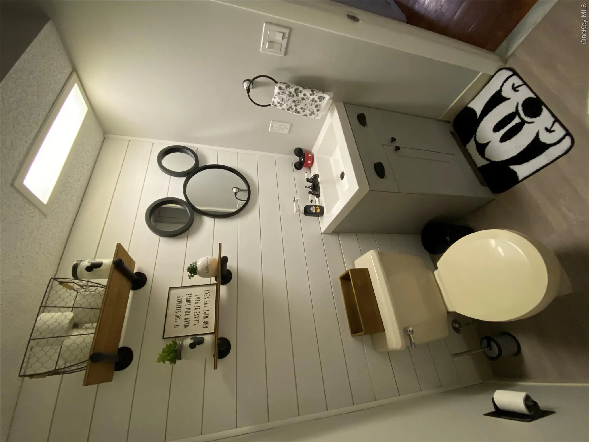 Powder room featuring a shiplap accent wall, light gray walls, and light wood-finish flooring Powder room featuring a shiplap accent wall, light gray walls, and light wood-finish flooring