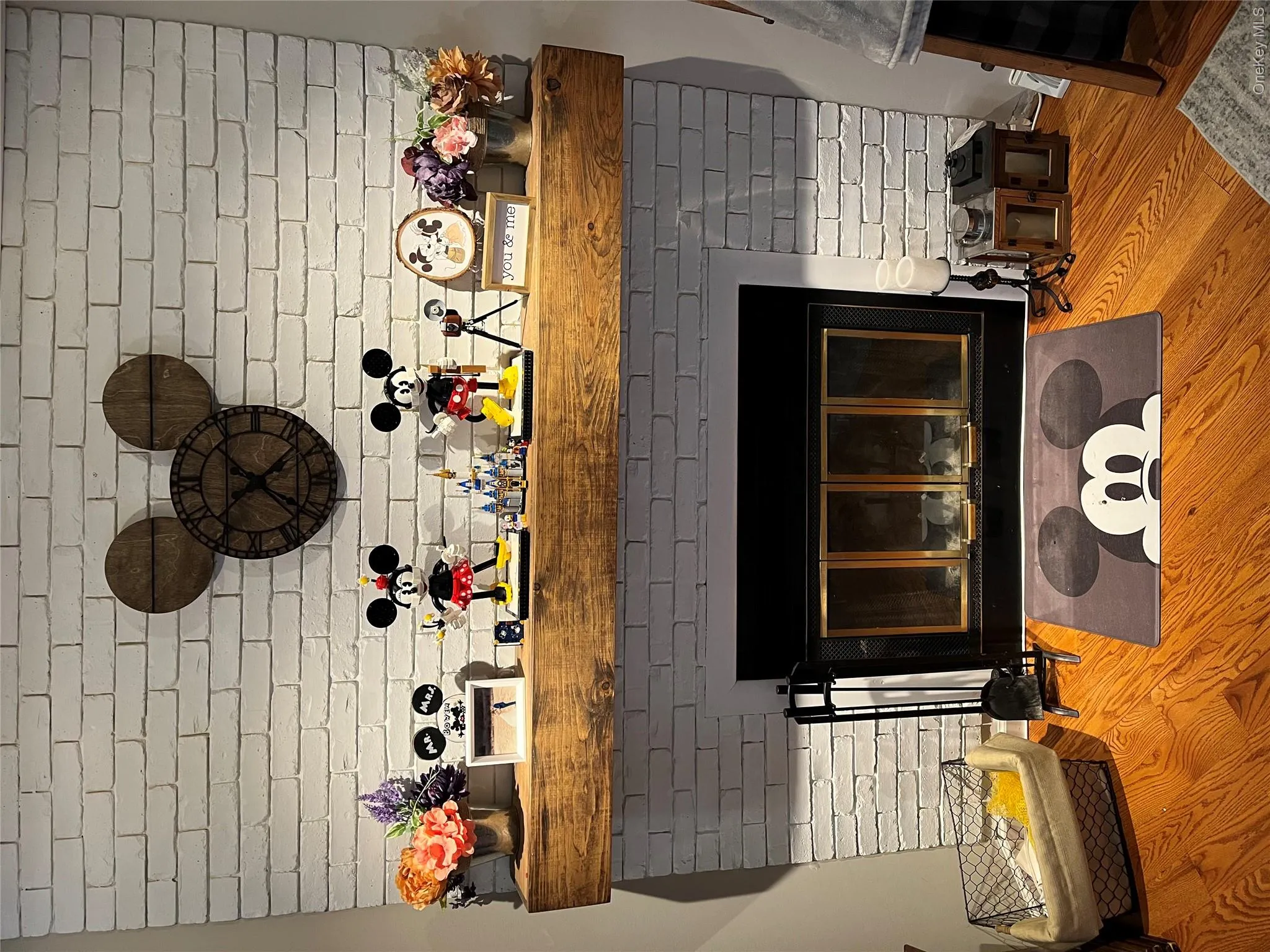 White-painted brick fireplace featuring a wood mantel White-painted brick fireplace featuring a wood mantel