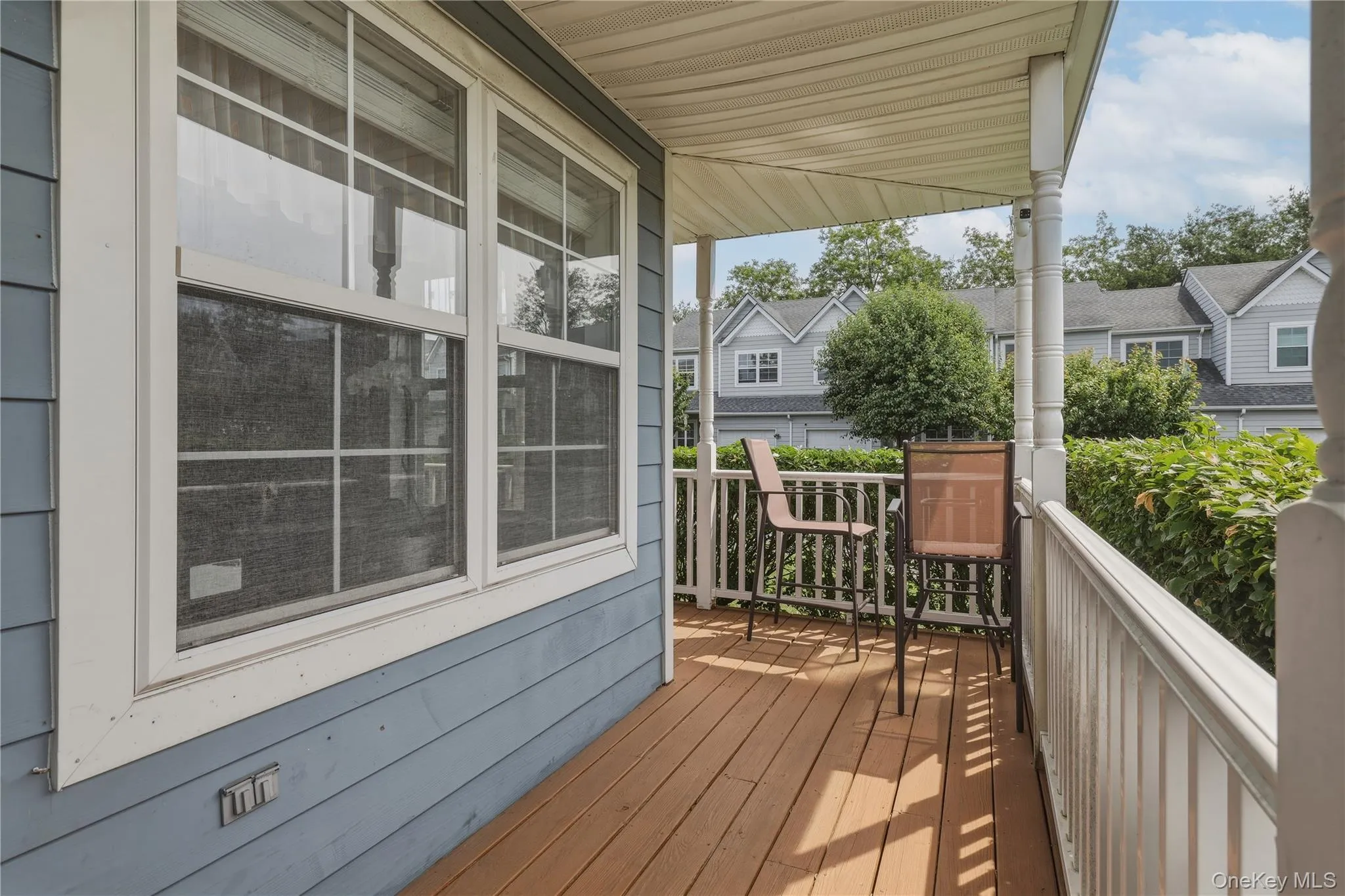 Covered porch featuring wood-finish flooring, white PVC railing, and columns Covered porch featuring wood-finish flooring, white PVC railing, and columns