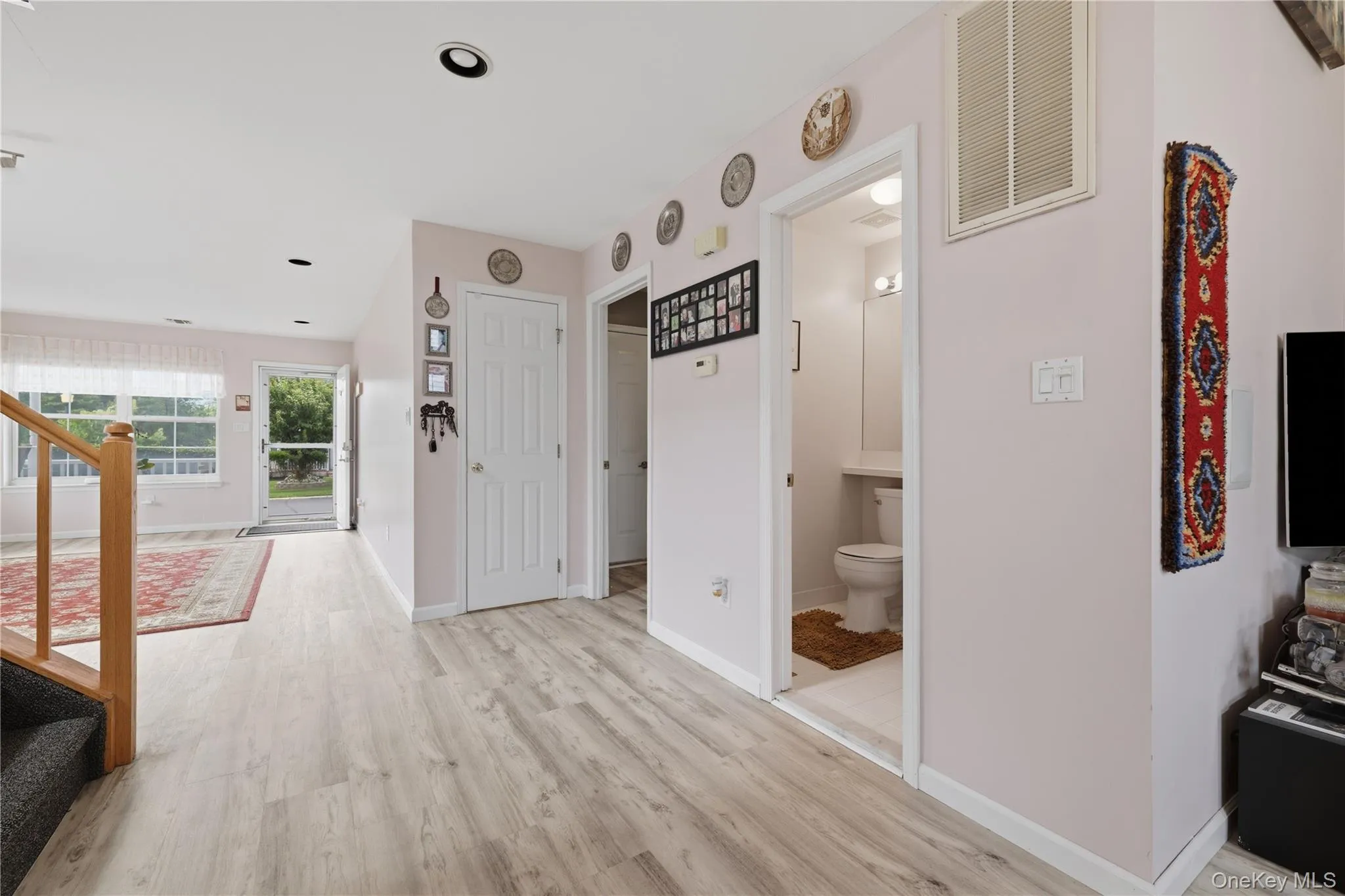 Light wood-finish flooring extending through hallway to kitchen Light wood-finish flooring extending through hallway to kitchen