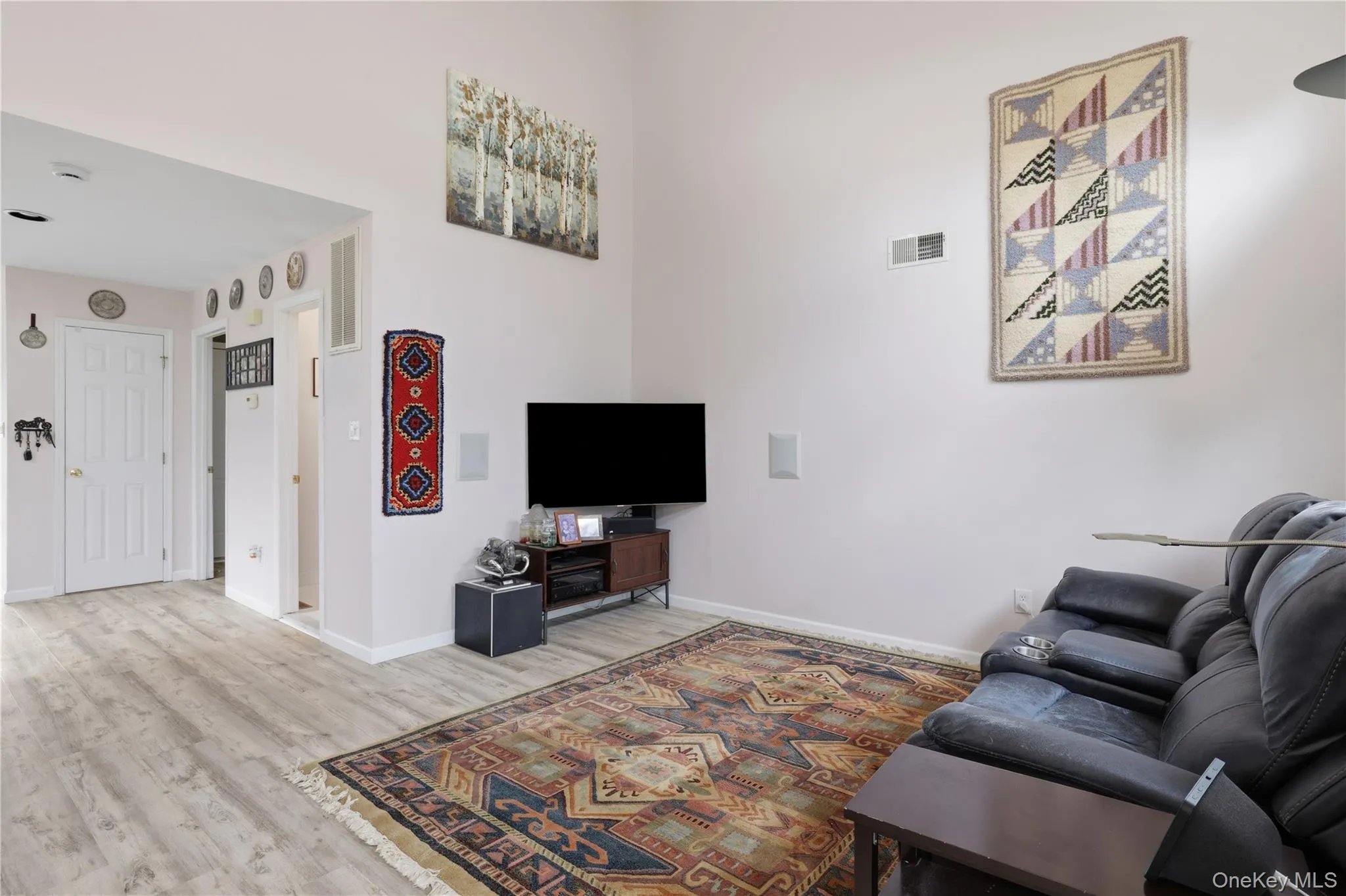 Living area featuring wood-finish flooring and a vaulted ceiling Living area featuring wood-finish flooring and a vaulted ceiling