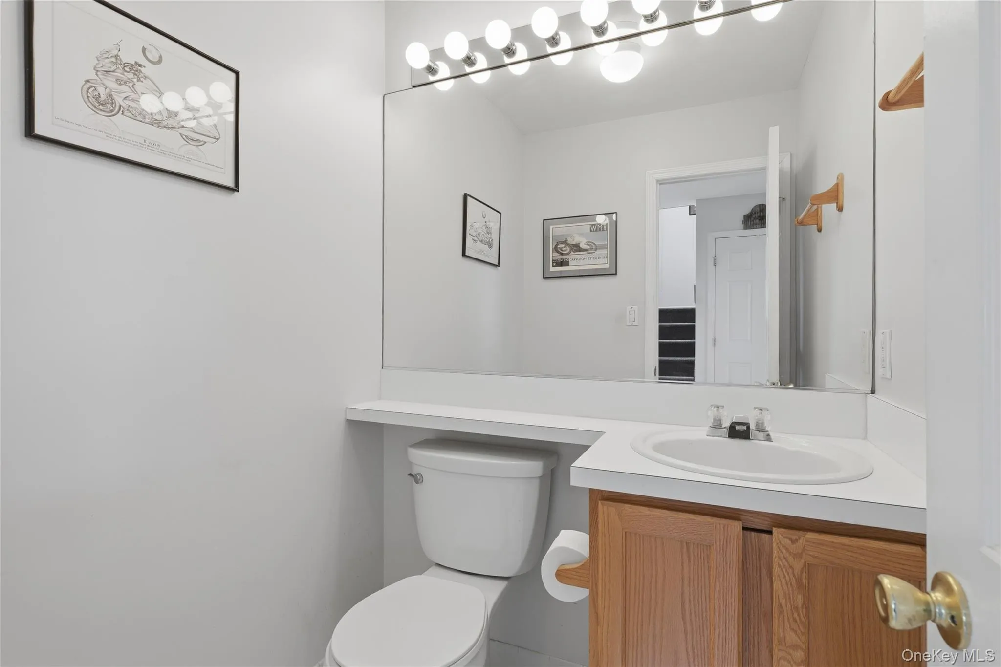 Half Bathroom featuring a vanity with wood-finish cabinetry, a white countertop, and an integrated sink Half Bathroom featuring a vanity with wood-finish cabinetry, a white countertop, and an integrated sink