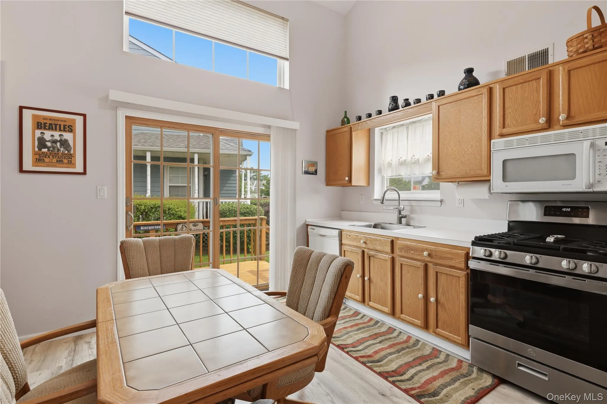 Kitchen area featuring a vaulted ceiling with upper transom windows, vinyl wood-finish plank flooring Kitchen area featuring a vaulted ceiling with upper transom windows, vinyl wood-finish plank flooring