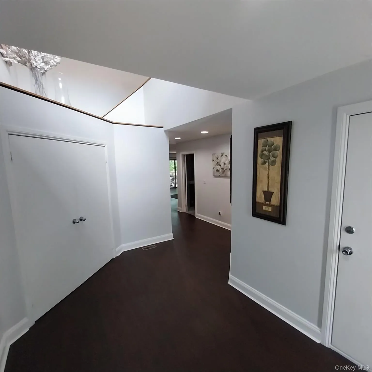 Entryway featuring dark wood-finish flooring, white baseboards, and light gray walls Entryway featuring dark wood-finish flooring, white baseboards, and light gray walls
