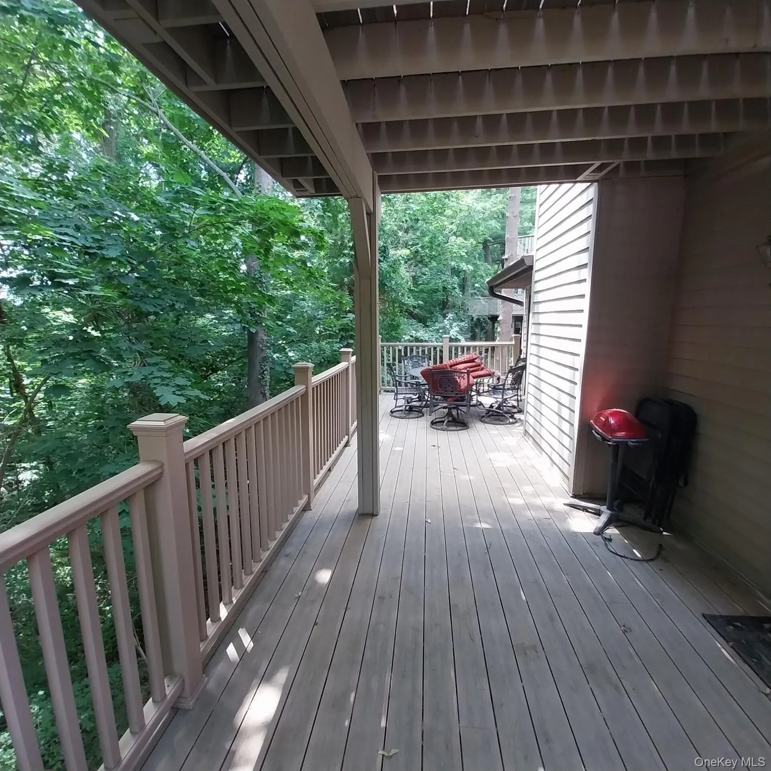 Expansive wood-finish deck with a solid railing, offering an elevated outdoor living area Expansive wood-finish deck with a solid railing, offering an elevated outdoor living area