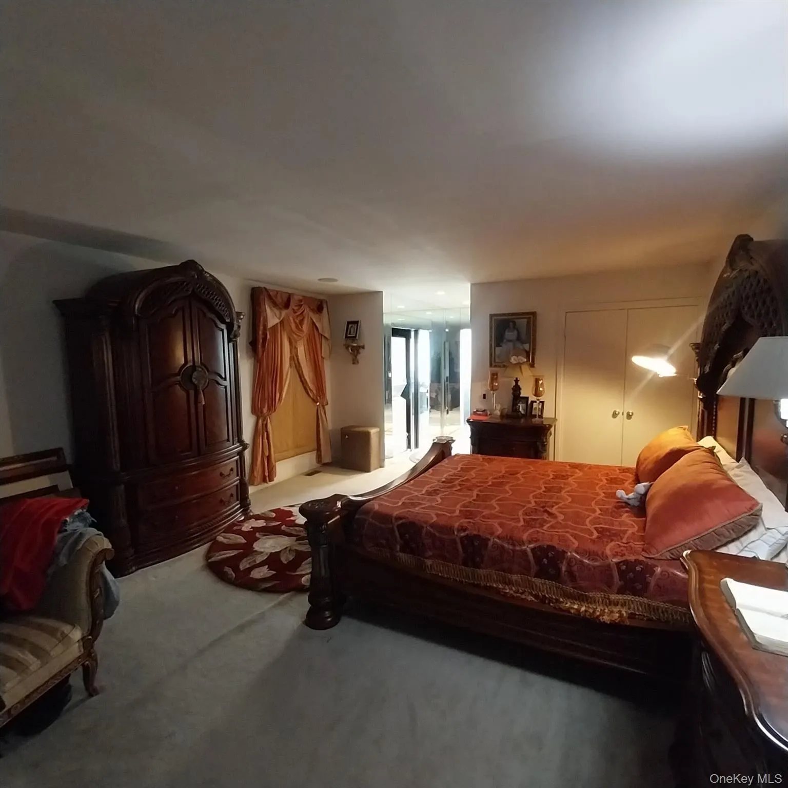 Carpeted room with a built-in wardrobe featuring carved details and a window dressed with draped valances Carpeted room with a built-in wardrobe featuring carved details and a window dressed with draped valances