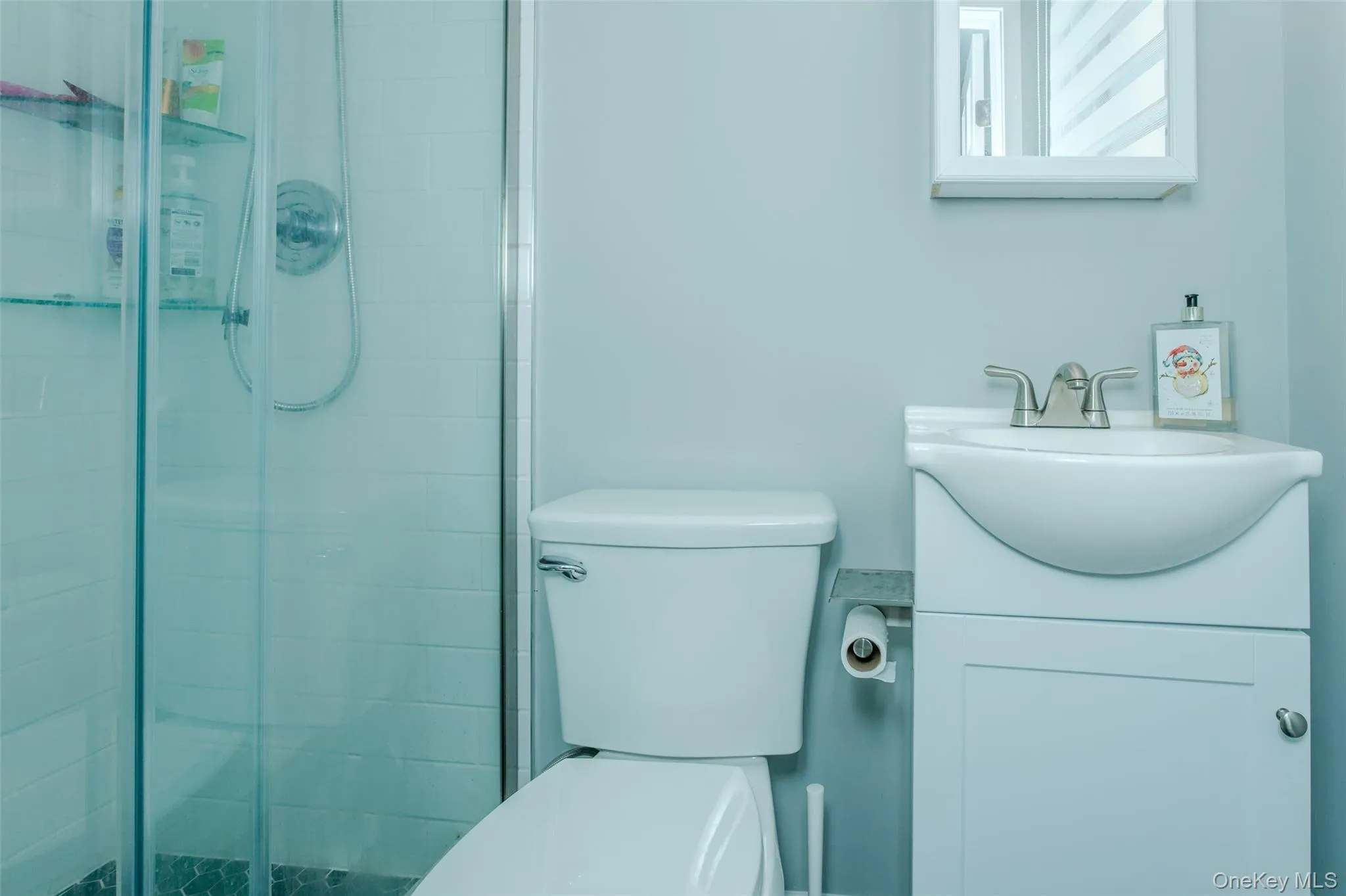 Bathroom featuring vanity, toilet, and a tile shower Bathroom featuring vanity, toilet, and a tile shower
