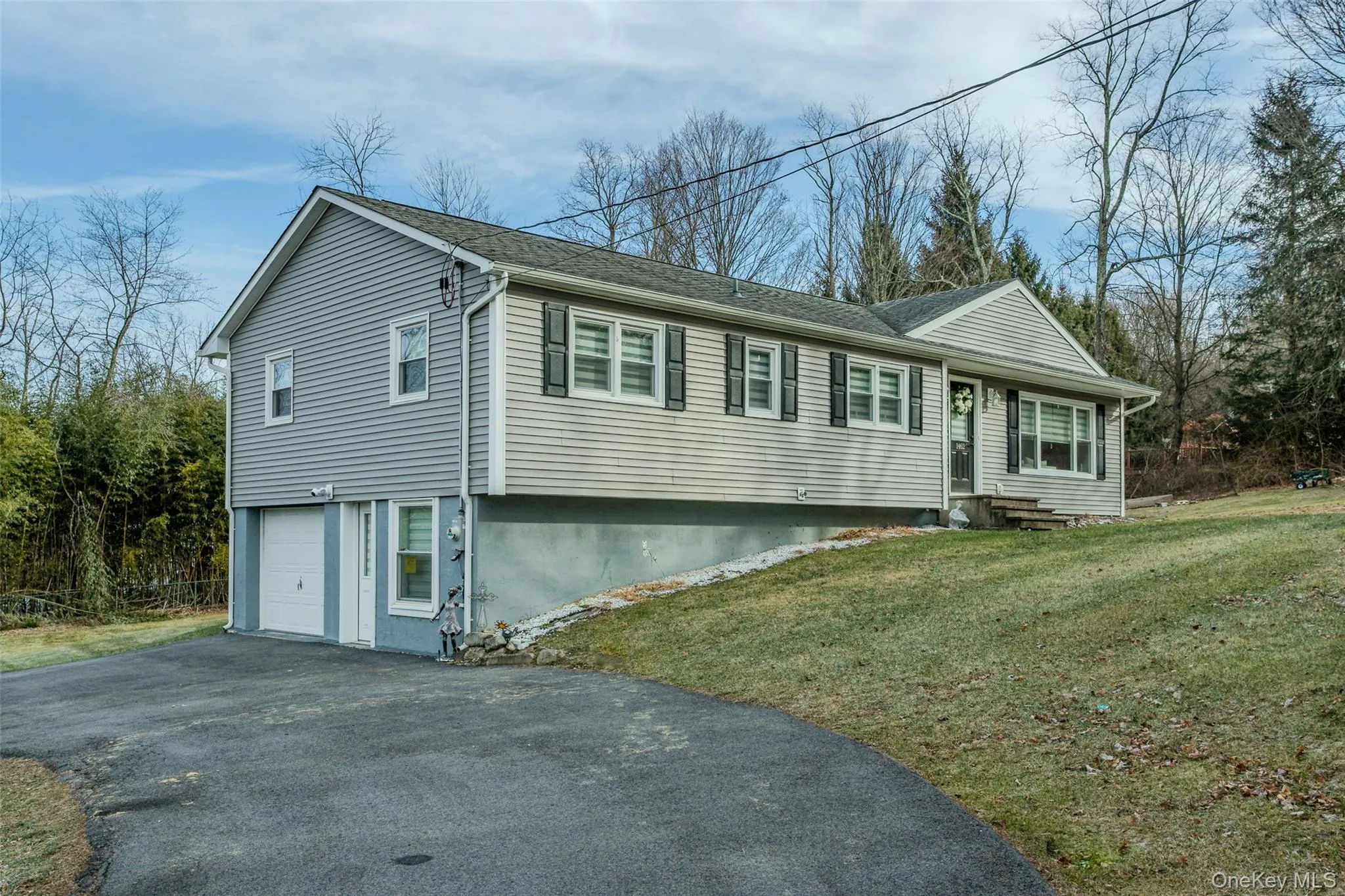 View of front of property featuring a garage and a front lawn View of front of property featuring a garage and a front lawn