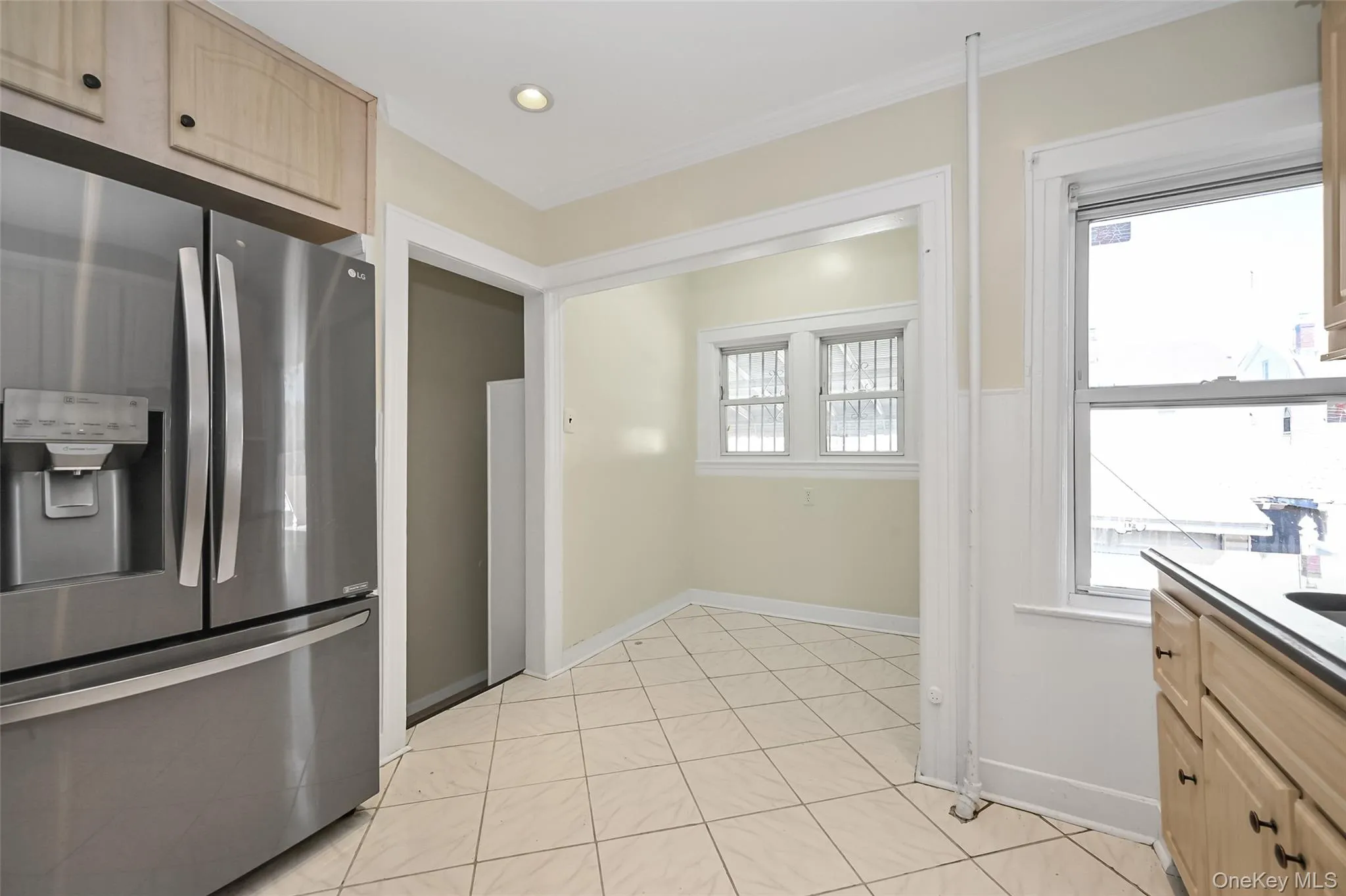 Kitchen featuring tile flooring, stainless steel French door refrigerator, recessed lighting, wood-finish cabinetry, and a bright window Kitchen featuring tile flooring, stainless steel French door refrigerator, recessed lighting, wood-finish cabinetry, and a bright window