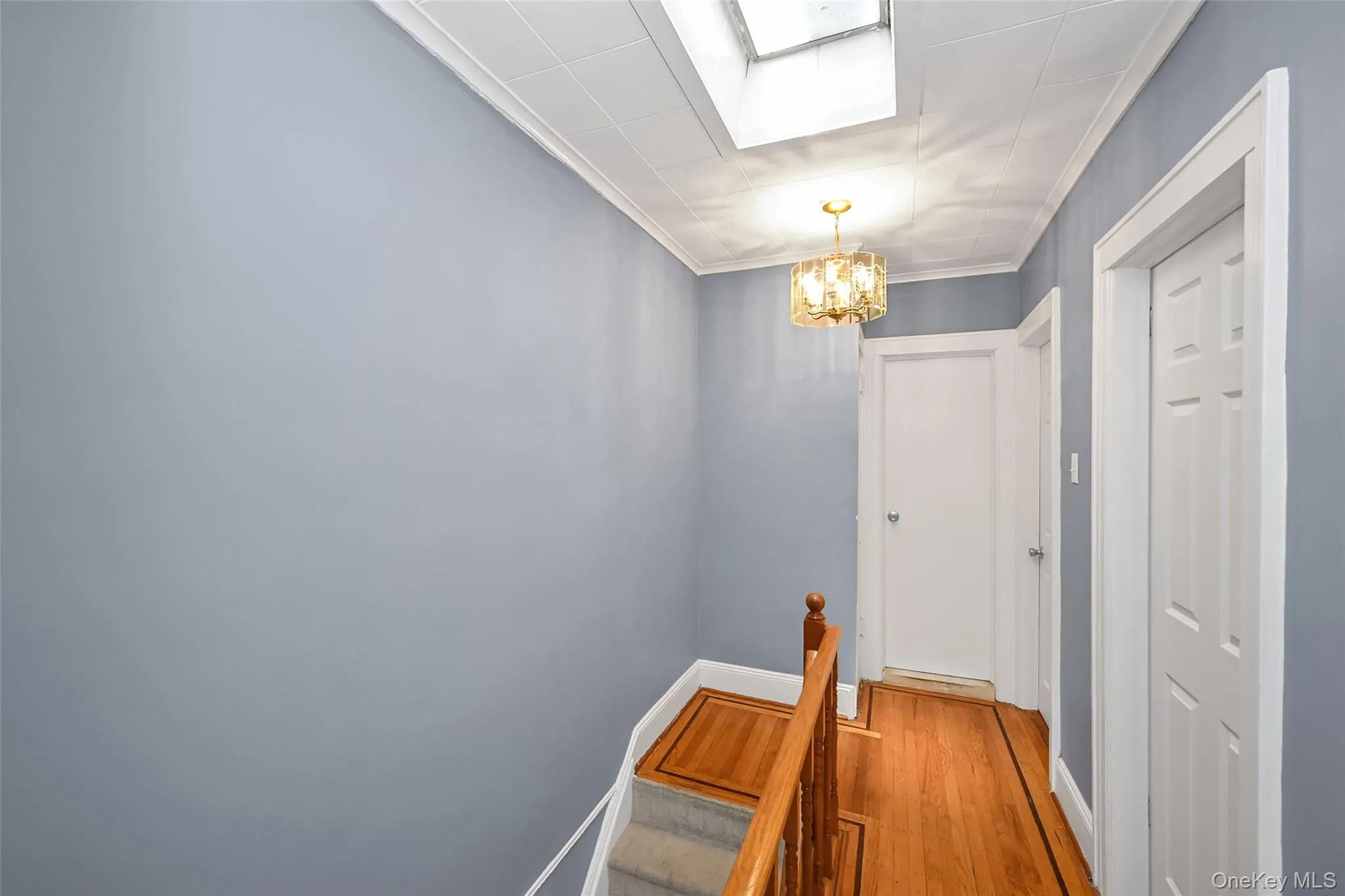A welcoming upper-level landing greets you with warm hardwood floors, elegant trim work, and a thoughtfully designed layout. Natural light from the overhead skylight brightens the space, creating an open and airy feel throughout. The neutral color palette provides a timeless backdrop, while ample hallway space offers easy access to the home's bedrooms and living areas. This charming transitional space adds both character and functionality, enhancing the home's overall appeal. ??? A welcoming upper-level landing greets you with warm hardwood floors, elegant trim work, and a thoughtfully designed layout. Natural light from the overhead skylight brightens the space, creating an open and airy feel throughout. The neutral color palette provides a timeless backdrop, while ample hallway space offers easy access to the home's bedrooms and living areas. This charming transitional space adds both character and functionality, enhancing the home's overall appeal. ???