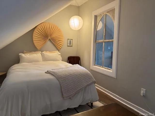 Bedroom with vaulted ceiling and wood finished floors Bedroom with vaulted ceiling and wood finished floors