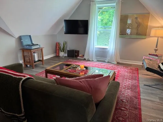 Living room featuring vaulted ceiling and wood finished floors Living room featuring vaulted ceiling and wood finished floors
