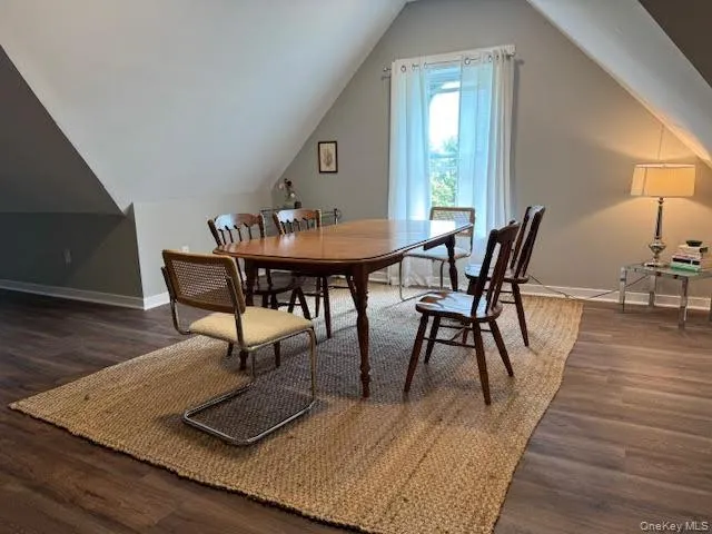Dining room featuring wood finished floors and vaulted ceiling Dining room featuring wood finished floors and vaulted ceiling