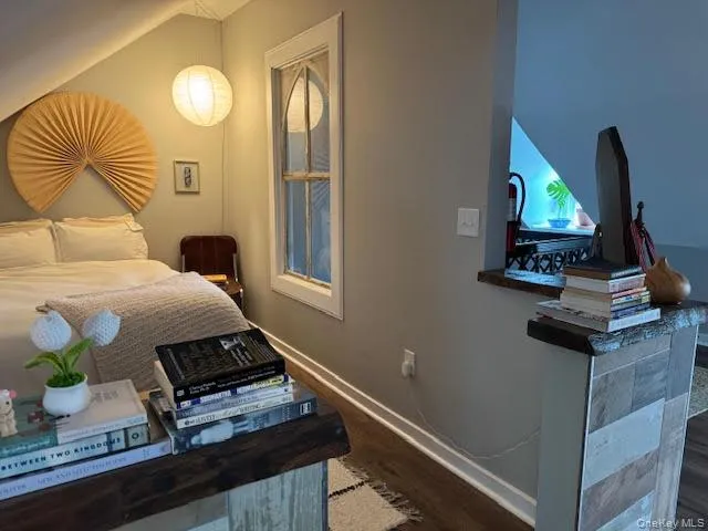Bedroom featuring dark wood-style floors and baseboards Bedroom featuring dark wood-style floors and baseboards