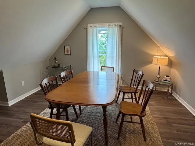 Dining room with wood finished floors and vaulted ceiling Dining room with wood finished floors and vaulted ceiling