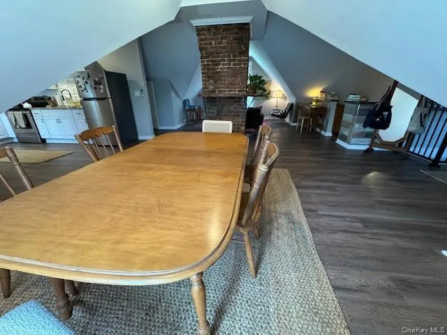 Dining room featuring wood finished floors and lofted ceiling Dining room featuring wood finished floors and lofted ceiling