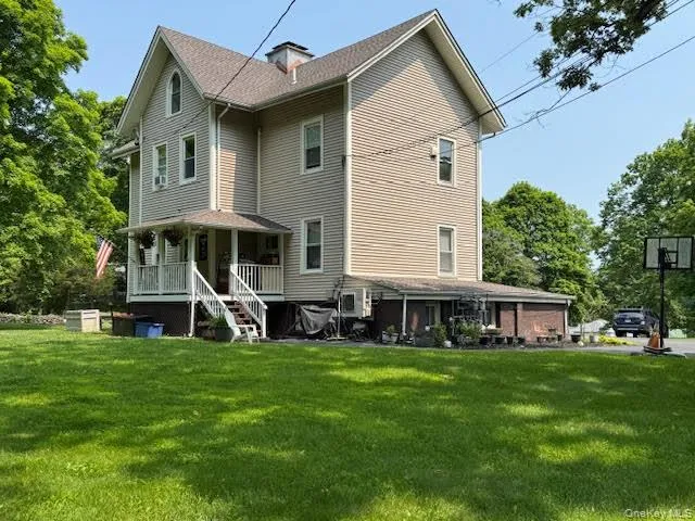 Back of house featuring covered porch and a yard Back of house featuring covered porch and a yard