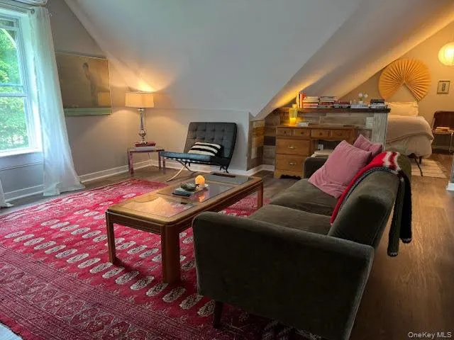 Living area with vaulted ceiling and wood finished floors Living area with vaulted ceiling and wood finished floors