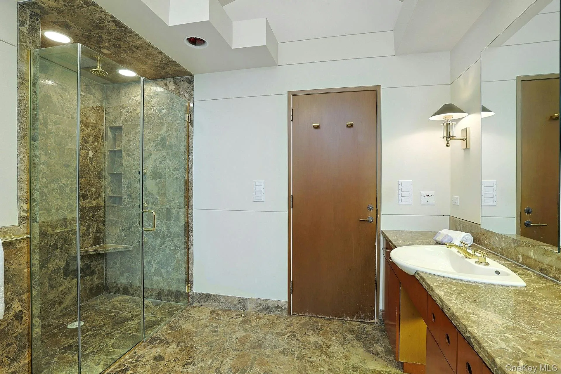 A spacious glass-enclosed shower, expansive vanity, and abundant storage complete this spa-inspired primary bath. A spacious glass-enclosed shower, expansive vanity, and abundant storage complete this spa-inspired primary bath.