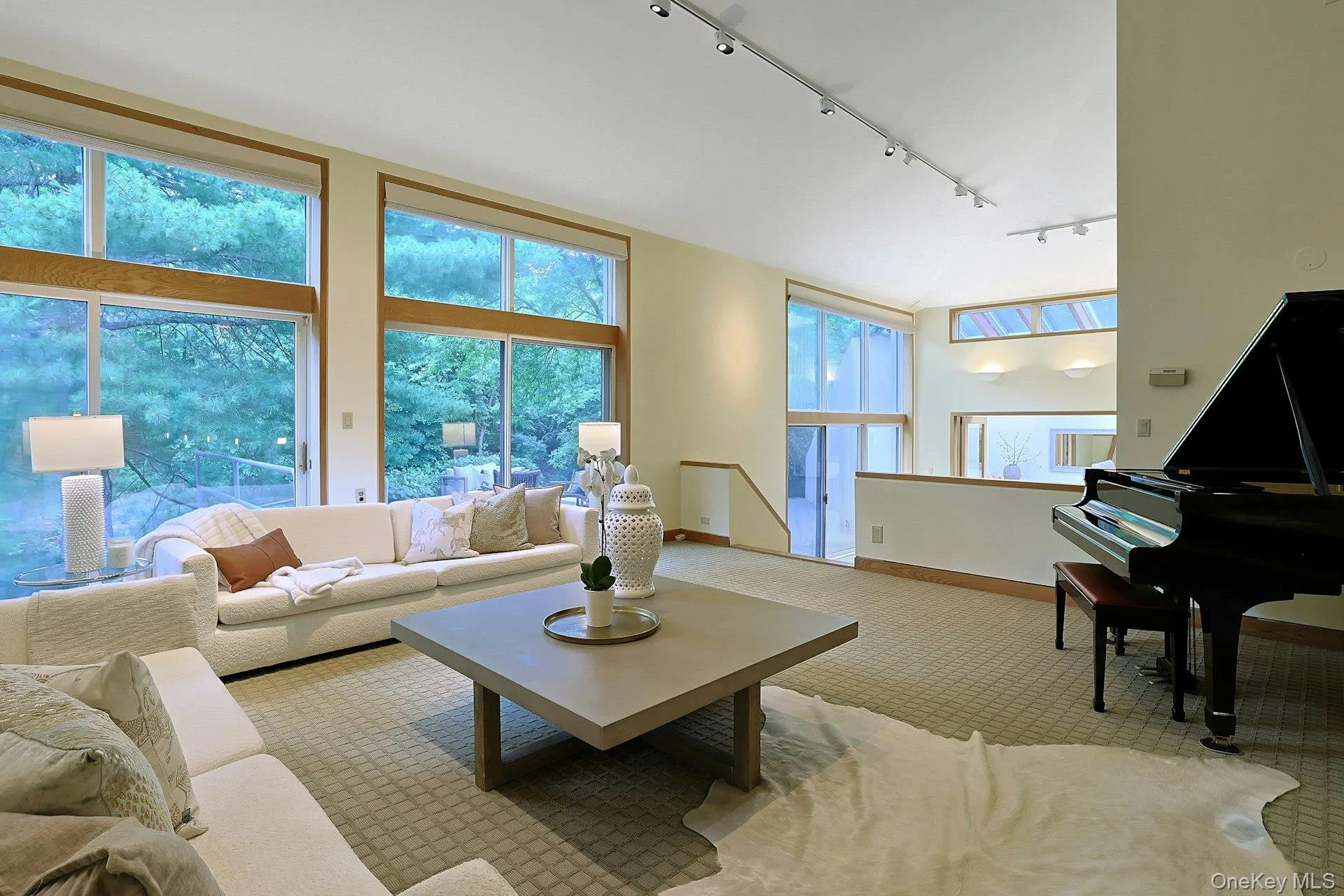 Formal living room with a wall of floor-to-ceiling windows fram picturesque views of the terrace and pond. Formal living room with a wall of floor-to-ceiling windows fram picturesque views of the terrace and pond.