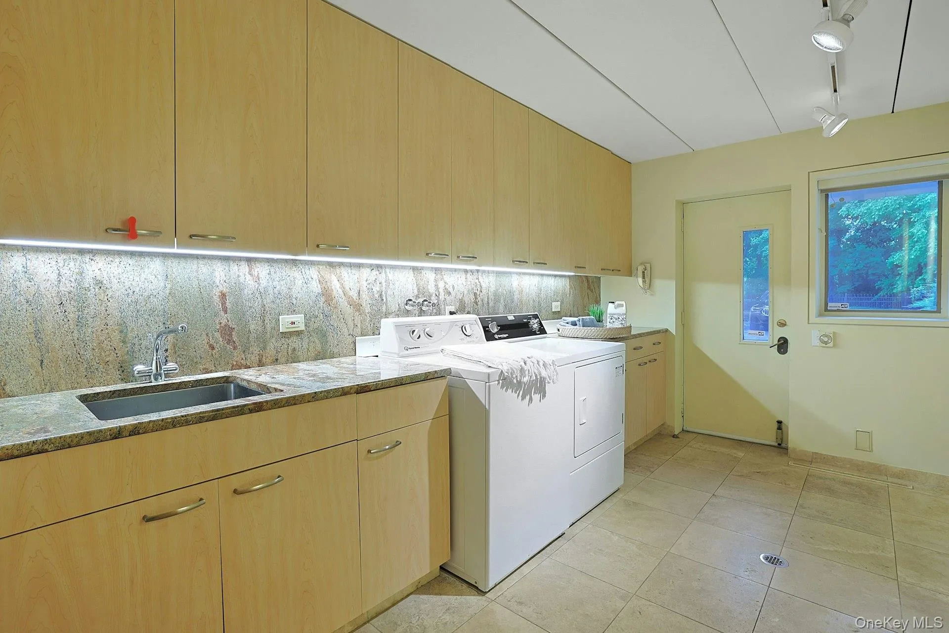 The expansive laundry and utility room provides abundant storage, workspace, and convenient access to the driveway and parking court. The expansive laundry and utility room provides abundant storage, workspace, and convenient access to the driveway and parking court.