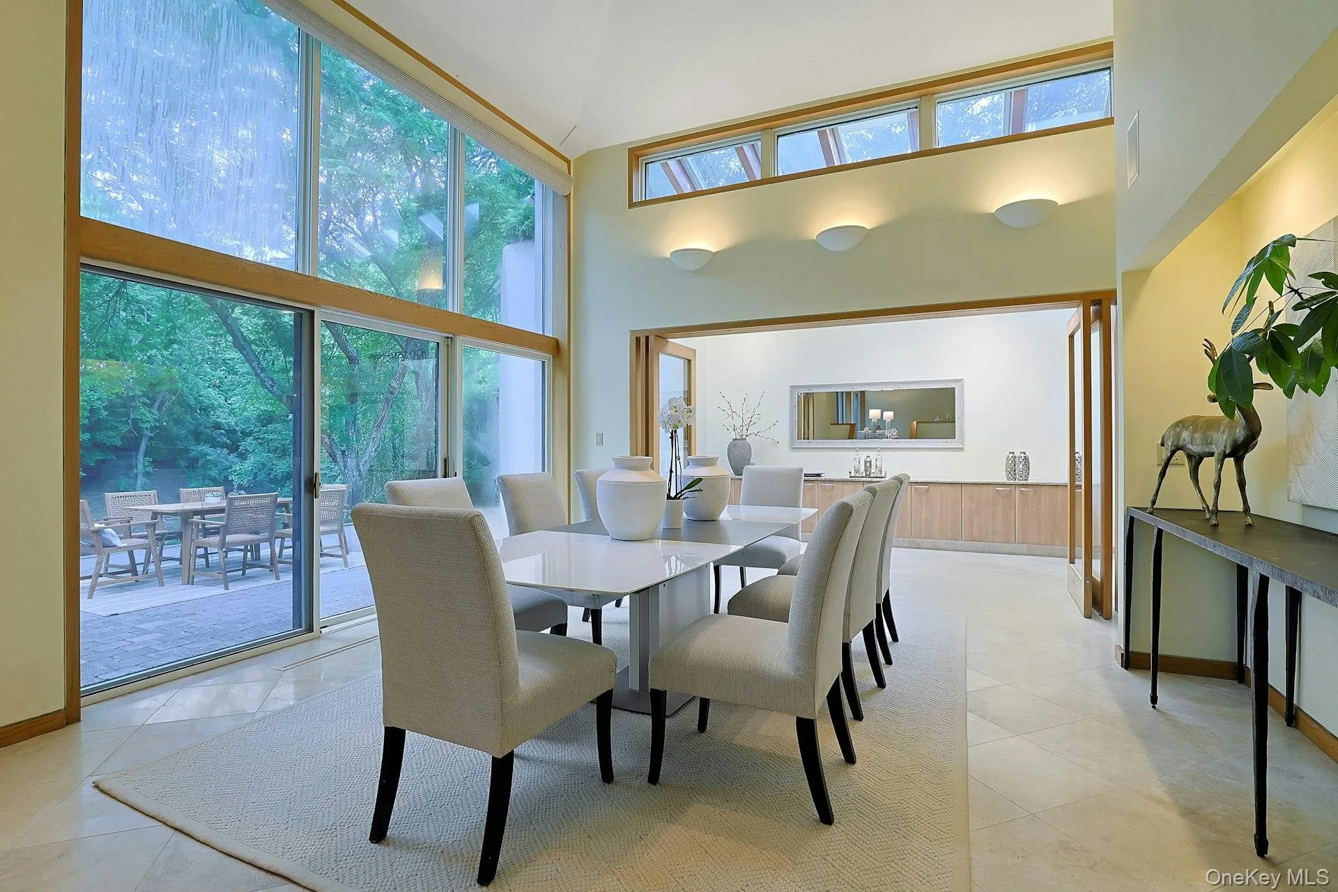 The elegant dining room is surrounded by walls of glass and opens effortlessly to outdoor entertaining spaces. The elegant dining room is surrounded by walls of glass and opens effortlessly to outdoor entertaining spaces.