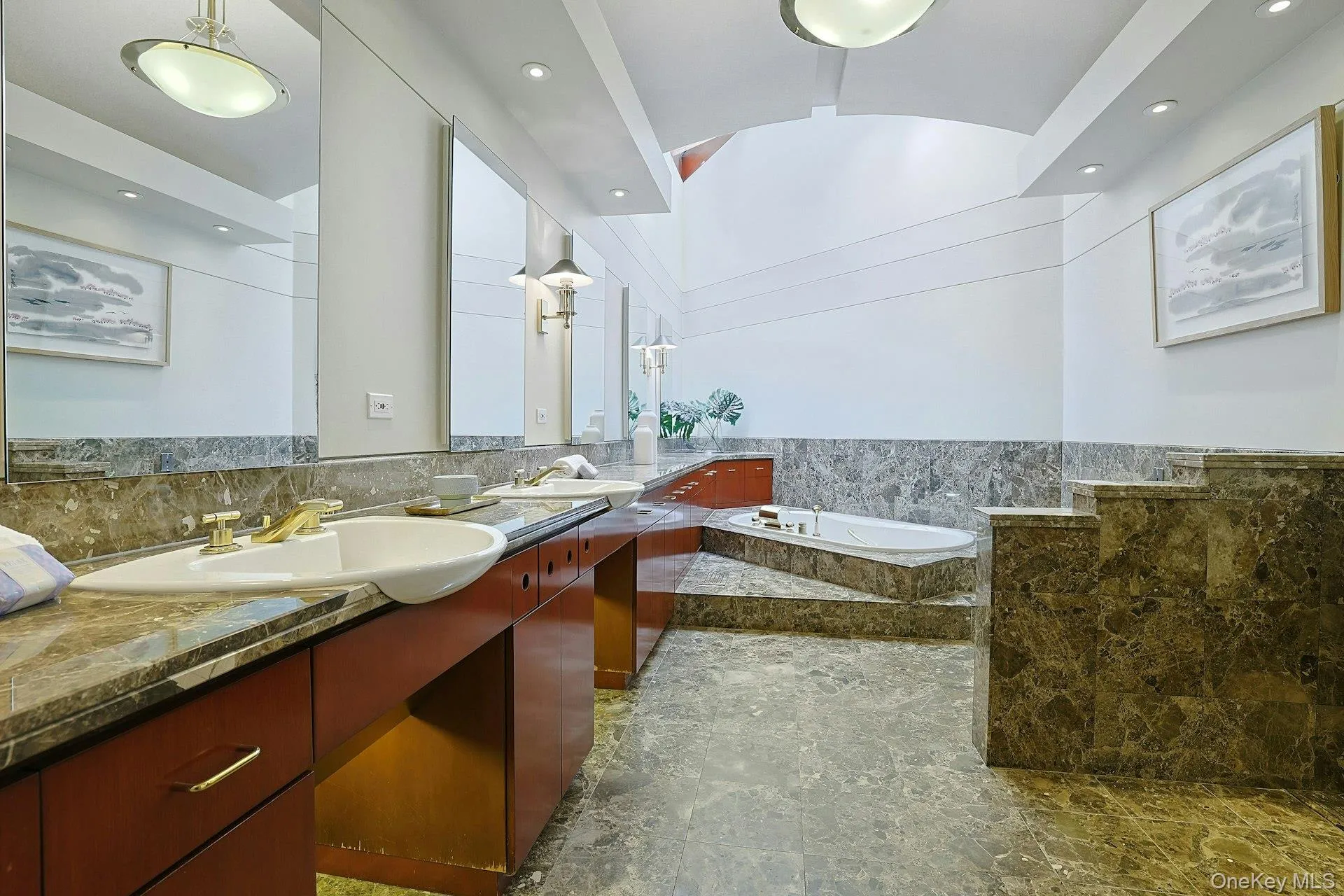 The luxurious primary bath features a skylight, oversized Jacuzzi tub, and elegant stone finishes throughout. The luxurious primary bath features a skylight, oversized Jacuzzi tub, and elegant stone finishes throughout.