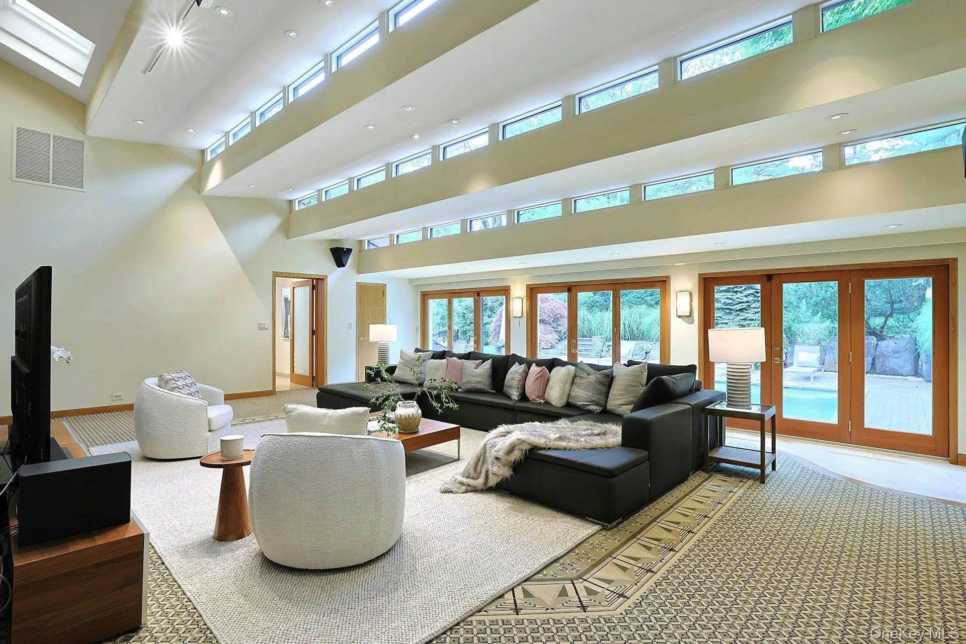 The extraordinary double-height family room showcases soaring ceilings, walls of glass, and seamless indoor-outdoor living. The extraordinary double-height family room showcases soaring ceilings, walls of glass, and seamless indoor-outdoor living.