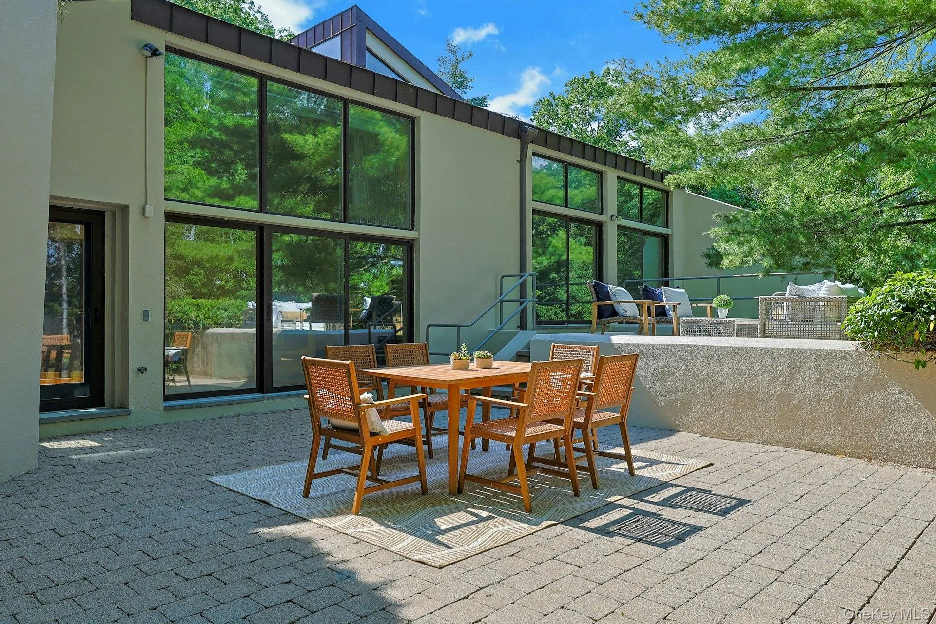 This spacious patio, perfect for al fresco dining, blurs the line between indoors and outdoors, enhancing the home's modern design and connection to nature. This spacious patio, perfect for al fresco dining, blurs the line between indoors and outdoors, enhancing the home's modern design and connection to nature.