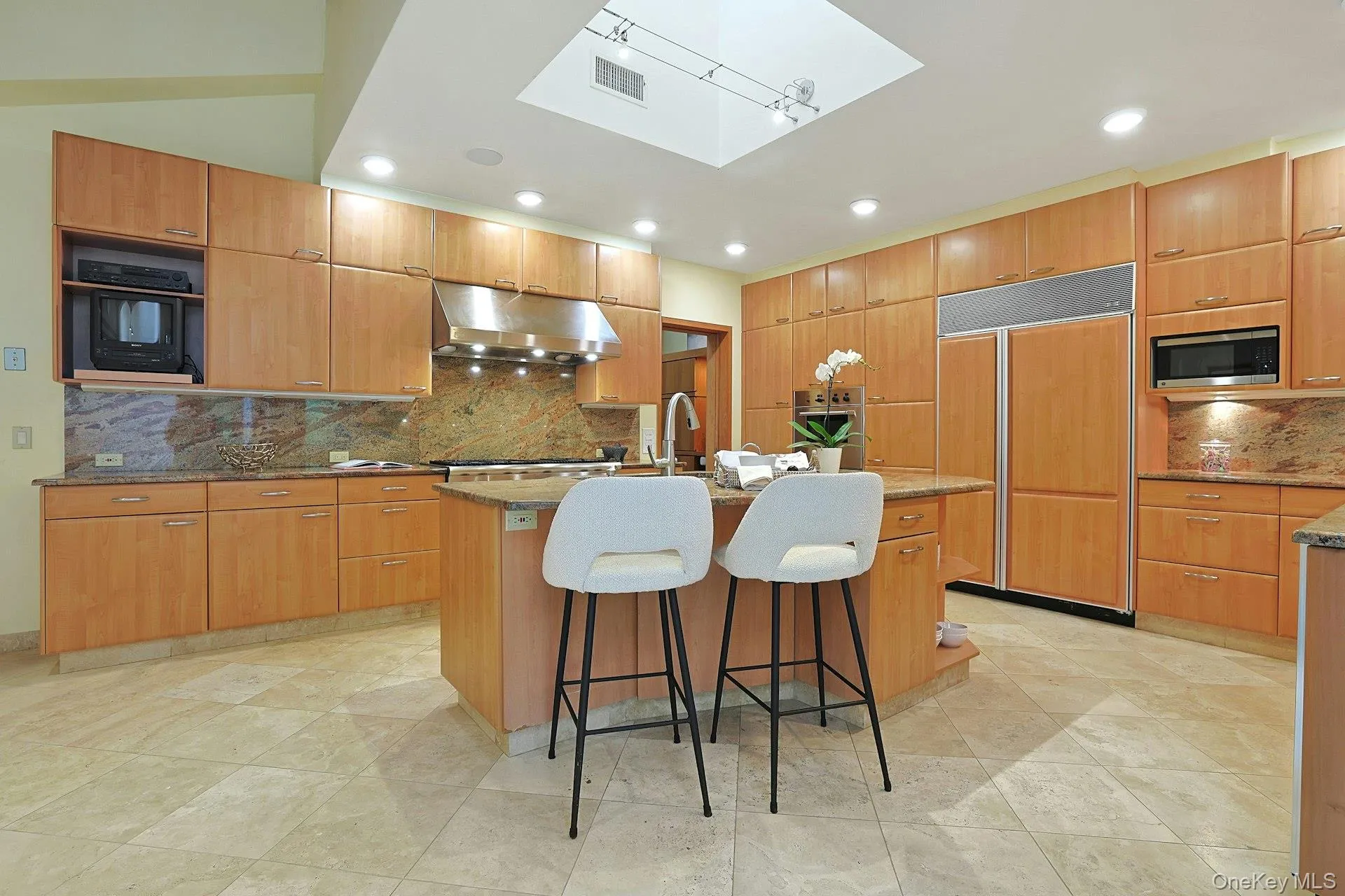 The chef's kitchen features custom oak cabinetry, granite countertops, premium appliances, and a large center island designed for gathering. The chef's kitchen features custom oak cabinetry, granite countertops, premium appliances, and a large center island designed for gathering.