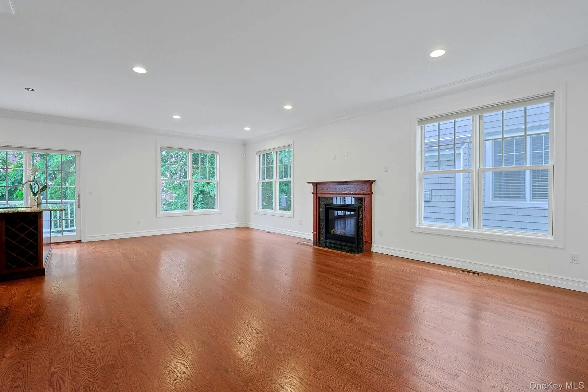 The expansive living room is anchored by a handsome gas fireplace and framed by large windows that fill the space with natural light throughout the day. The expansive living room is anchored by a handsome gas fireplace and framed by large windows that fill the space with natural light throughout the day.